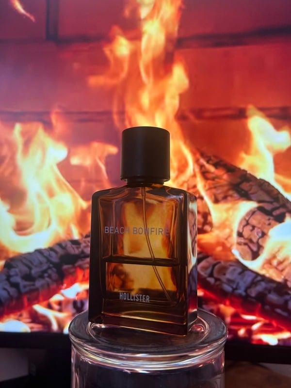 Amber perfume bottle photographed against a fireplace
